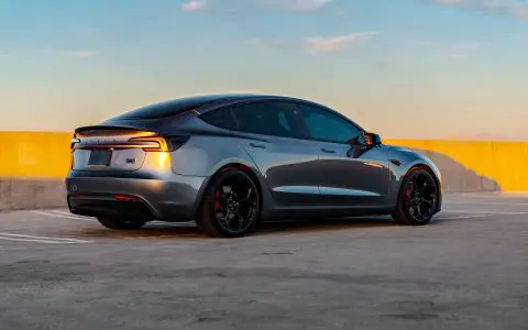 A rear shot of a Quicksilver Tesla Model 3 Performance with UP-05 Forged Wheels parked in a parking lot.