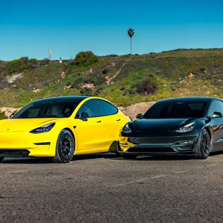 Dark Emerald Metallic Tesla Model 3 Performance Side By Side with Yellow Wrapped Tesla Model 3