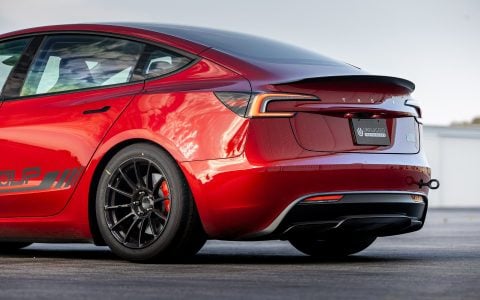 Detailed view of UP-03 Gloss Black Forged Wheels and red Tesla brake calipers on the rear of a Tesla Model 3 Performance.