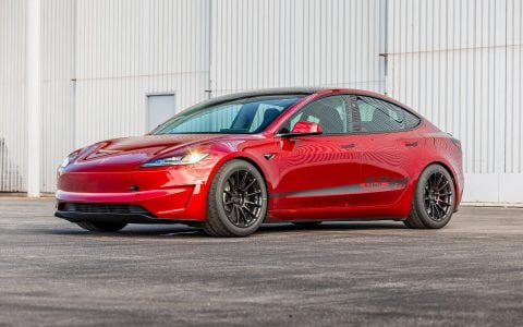 Tesla Model 3 Performance in Ultra Red with Unplugged Performance UP-03 Forged Wheels in Gloss Black, showcasing aggressive front design and enhanced aerodynamics.