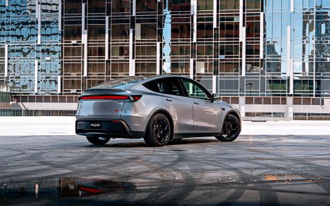 A rear three quarter shot of a 2026 Tesla Model Y Launch Edition with Satin Black 19 inch UP-05 Forged Wheels parked in front a nice background.